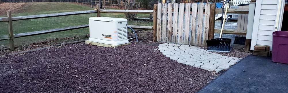 A Generator placed in corner of a garden's wooden fencing at Blairstown, NJ